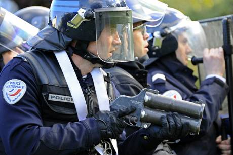 An anti-riot policeman faces youths during clashes in Nanterre 